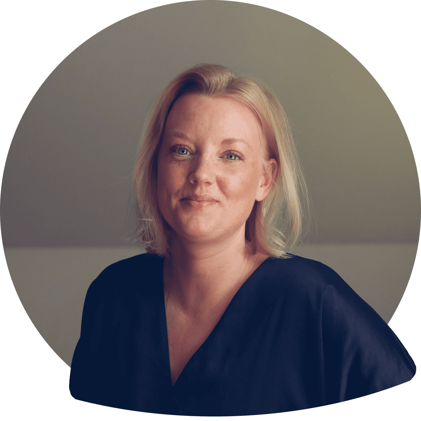 Anna smilende i blondt skulderlangt hår i lys bluse. Foto.