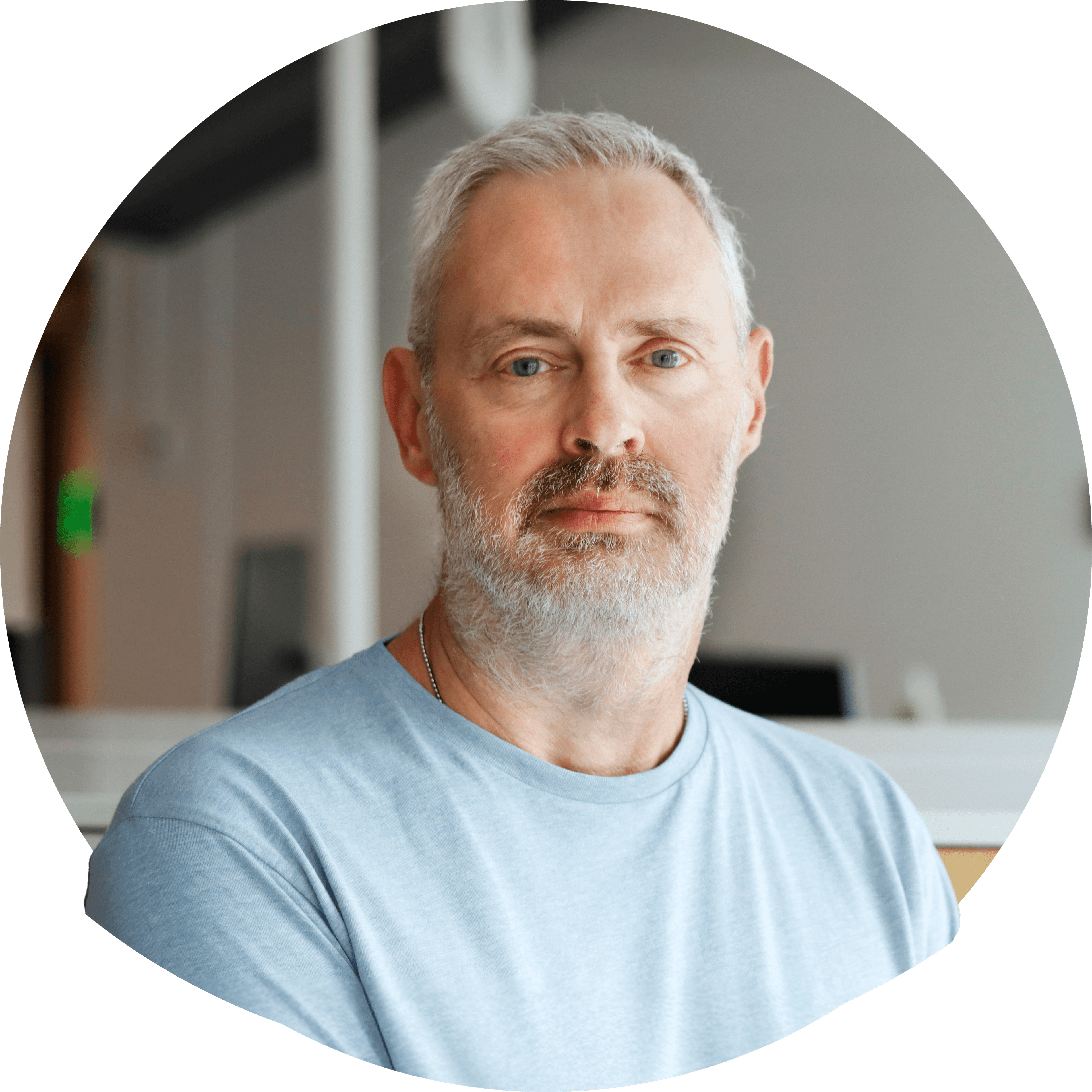 Tommy O i kort sølvfarget hår og kort skjegg i lys t-skjorte. Foto.