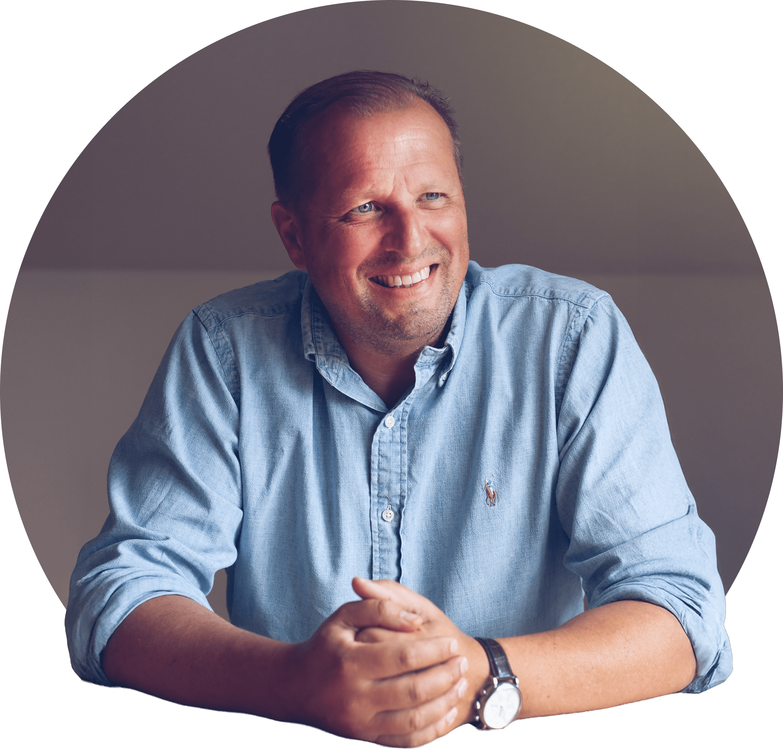 Fredrik leende med skrattgropar, brun kort frisyr i ljus skjorta. Foto.